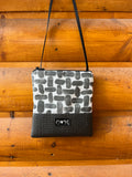 OlovesM black with a black and white USA made fabric. The Stella Crossbody bag handcrafted in the USA from a recycled yoga mat base and upcycled fabrics. Sustainable, vegan, and water-resistant.